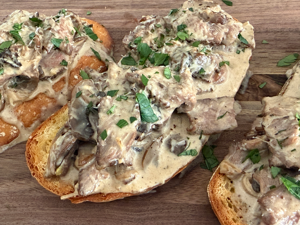 Beef Tip Crostini appetizer with tender steak bites on toasted baguette slices.